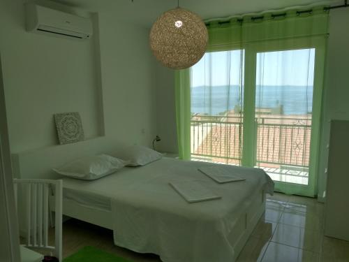 a bedroom with a bed and a large window at Apartments Viskovic in Makarska