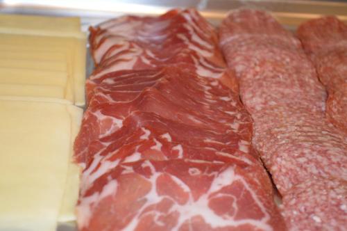 a row of cured meats sitting on a table at Hotel Villa Diana in Split