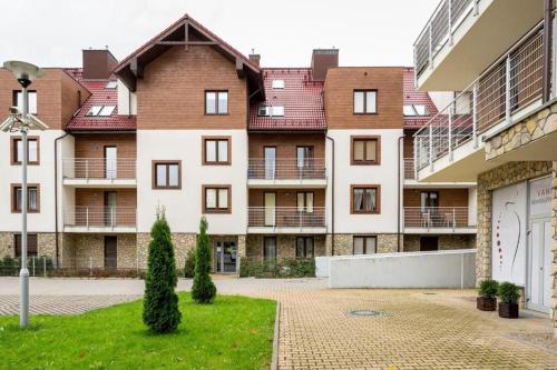 a large apartment building with a courtyard with trees at Apartament słoneczny in Polanica-Zdrój