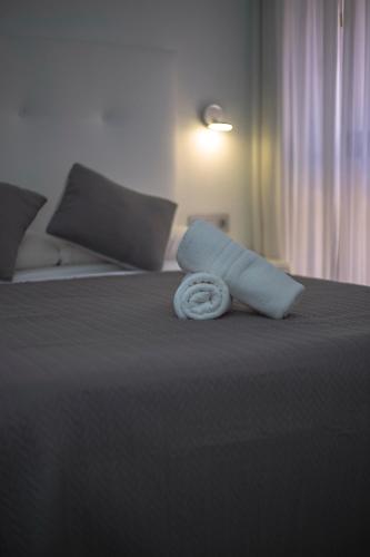 a rolled up towel sitting on top of a bed at Apartamentos Domus con parking gratuito in Granada