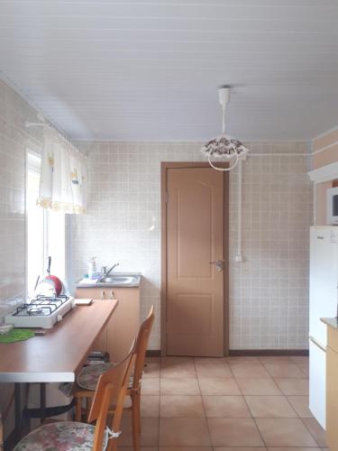 a kitchen with a table and chairs and a door at Česlovos sodyba in Zarasai
