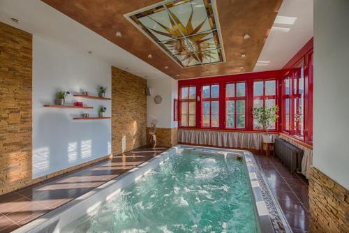 a large indoor pool in a room with red windows at Hotel Zlatý Orel in Ostravice