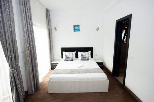 ママイア・ノルドにあるCittadini Residenceの白いベッドルーム(白いベッド1台、鏡付)