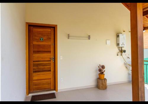 a room with a wooden door and a phone at Apart Avenida Monte Verde in Monte Verde