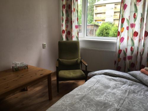 a bedroom with a bed and a chair and a window at Veriora apartment in Veriora