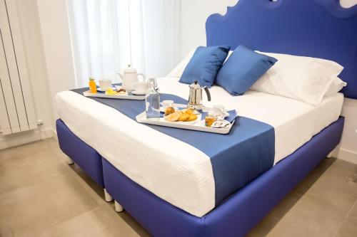 Una cama azul y blanca con una bandeja de comida. en Kerbaker 14 en Nápoles