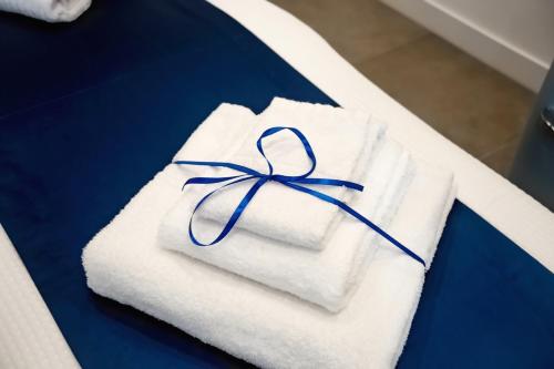 Una toalla blanca con una cinta azul. en Kerbaker 14 en Nápoles