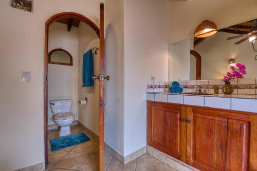 a bathroom with a toilet and a mirror at Casa de Arcos in Granada