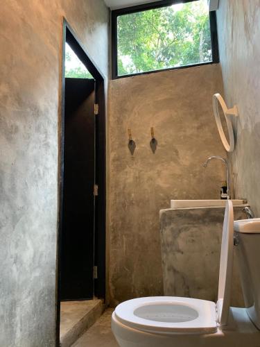 a bathroom with a toilet and a window at BeachBox@Koh Сhang in Ko Chang