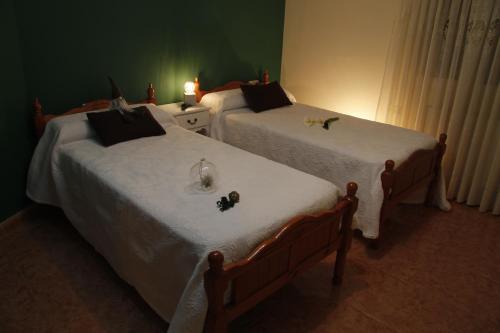 two twin beds in a bedroom with white sheets at Areeta Etxea in Espejo
