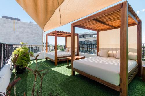 1 dormitorio con 2 camas en un balcón en Suites Corazon en Playa del Carmen