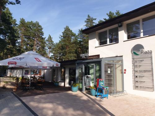 a store with an umbrella next to a building at Plaża Resort in Morąg