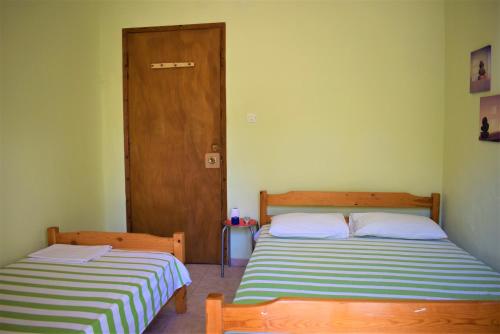 アスプロヴァルタにあるApartments Anesis Pantazisのドア付きの部屋のベッド2台