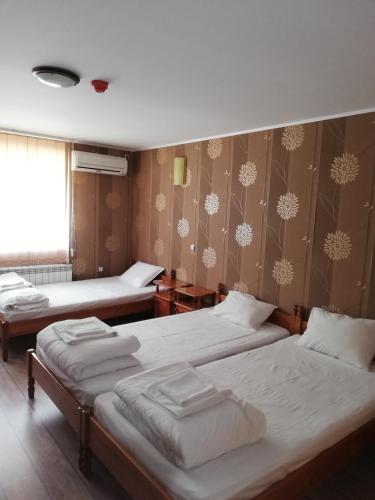 a bedroom with two beds and a wall with snow at Комплекс Рожена, хотел, хотелски комплекс Рожена in Rozhen