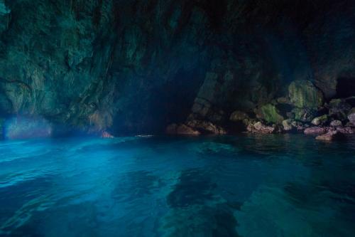 a cave with blue water and rocks in it at Hotel Villa Maria Pia in Praiano