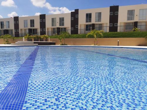 a swimming pool with blue tiles in front of a building at CASA VACACIONAL CONDOMINIO BAHÍA SOLERO in Girardot