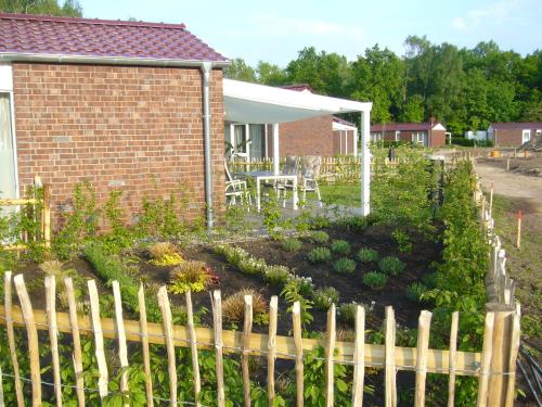 a garden with a fence in front of a house at Ferienhaus Nr 6 am Quendorfer See in Schüttorf