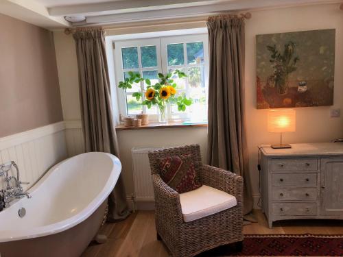 a bathroom with a tub and a chair and a window at Winterton in Lochgilphead