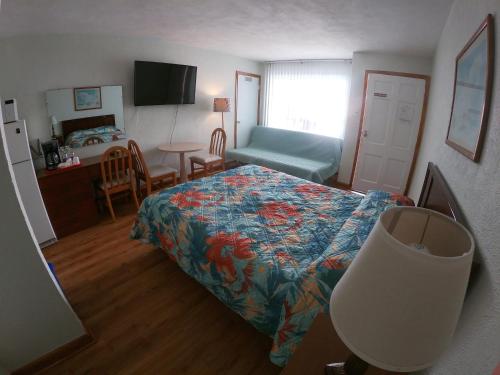 a bedroom with a bed and a table and a chair at Sea Chest Motel Dot Com for Deals! in Wildwood Crest
