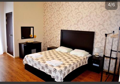 1 dormitorio con 1 cama con cabecera negra en U Morya Guesthouse, en Sukhum