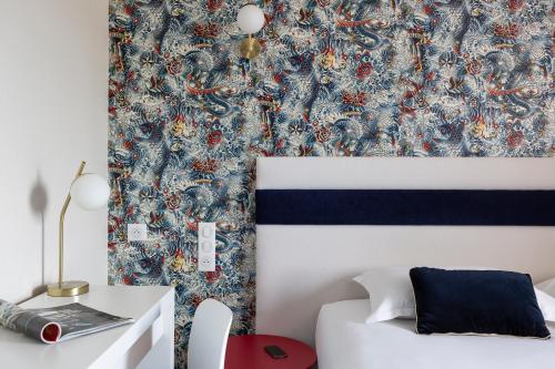 - une chambre dotée d'un lit avec du papier peint bleu et rouge dans l'établissement Hotel l'Ortega Rennes Aeroport, à Saint-Jacques-de-la-Lande