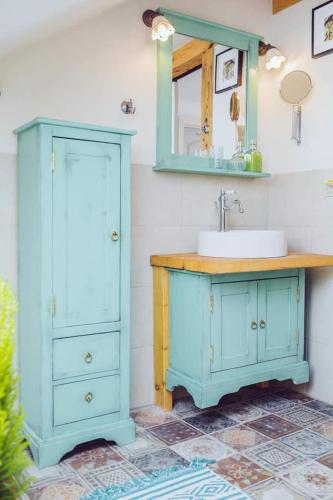 a bathroom with a sink and a blue cabinet at Strieborný dvor in Banská Štiavnica