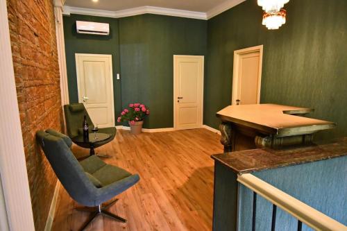 a living room with green walls and a desk and a chair at Hotel 1887 in Kutaisi