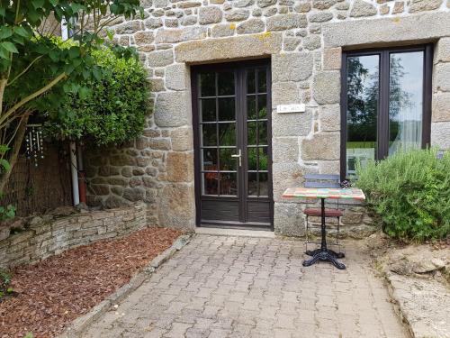a table in front of a stone building with a door at Le Grand Domaine du Rocher in Bonnemain