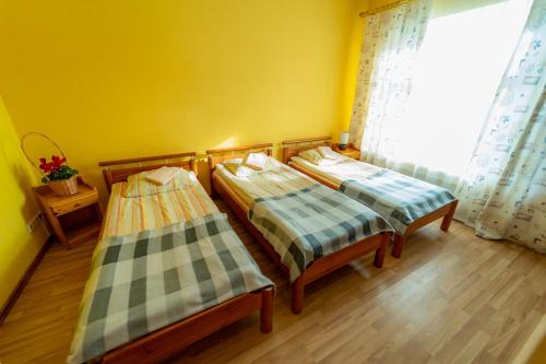 two beds in a room with a window at Hotel Mare & Restaurant in Roja