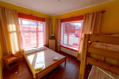 a bedroom with two bunk beds and two windows at Hotel Mare & Restaurant in Roja