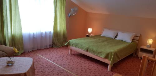 a bedroom with a green bed and a window at Hotel Mare & Restaurant in Roja