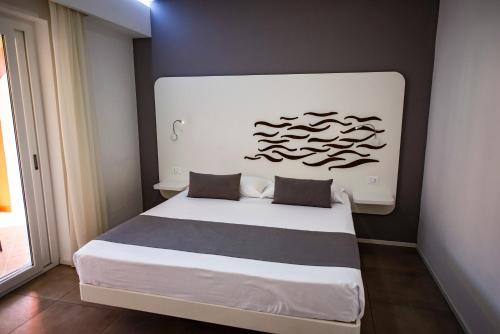 a bedroom with a large white bed in a room at Aether Suites Tropea - Free Private Parking in Tropea