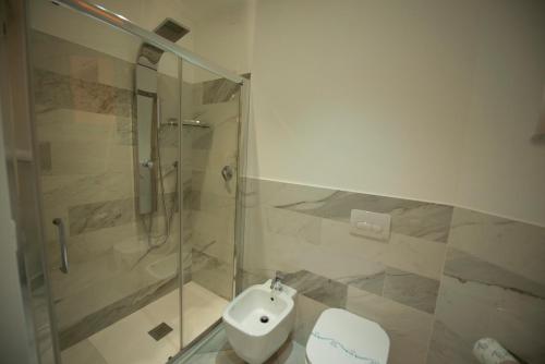a bathroom with a shower and a toilet and a sink at Aether Suites Tropea - Free Private Parking in Tropea
