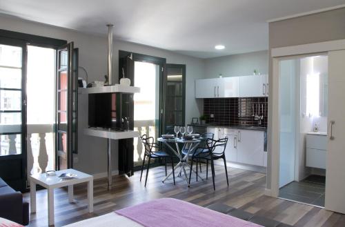 een woonkamer en een keuken met een tafel en stoelen bij Acio Tinto Loft Casco Histórico de Ourense in Ourense