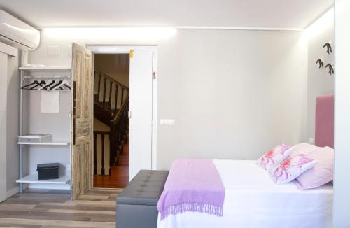 biała sypialnia z łóżkiem i schodami w obiekcie Acio Tinto Loft Casco Histórico de Ourense w mieście Ourense