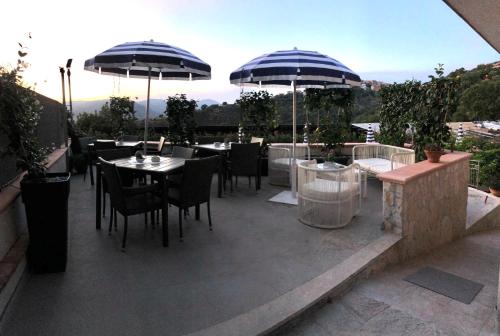 a patio with tables and chairs and umbrellas at B&B Nonna Valentina in Centola