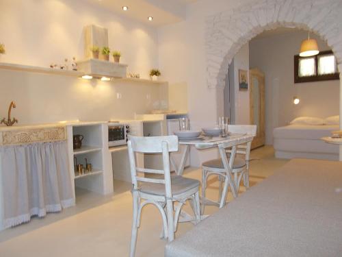 a kitchen and living room with a table and chairs at Three Little Roses Country House in Mési