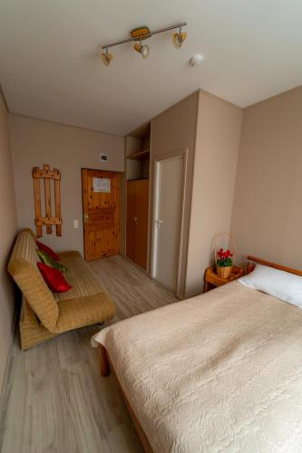 a bedroom with a bed and a chair in it at Hotel Mare & Restaurant in Roja