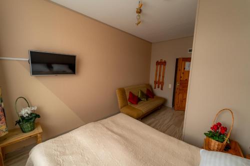 a bedroom with a bed and a tv on the wall at Hotel Mare & Restaurant in Roja