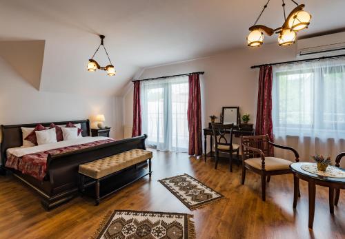 a bedroom with a bed and a table and chairs at Flora Luxury House in Sighişoara