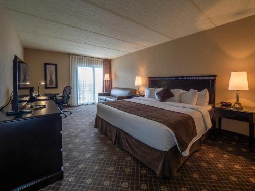 a hotel room with a large bed and a television at Le President Sherbrooke in Sherbrooke
