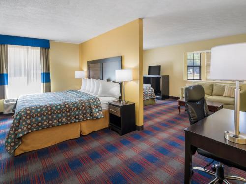 a hotel room with a bed and a desk at Americas Best Value Inn - Clayton in Clayton