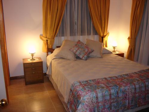 1 dormitorio con 1 cama con 2 lámparas en Turismo Vinapu en Hanga Roa