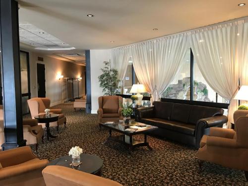 a hotel lobby with couches and tables and a window at Le President Sherbrooke in Sherbrooke