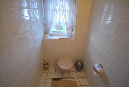 a small bathroom with a toilet and a window at Ferienwohnung -Am Kanal- in Nordgeorgsfehn