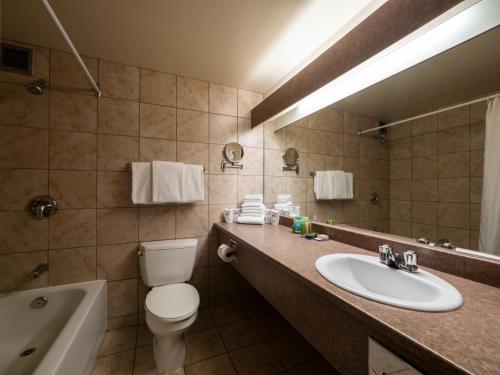 La salle de bains est pourvue d'un lavabo, de toilettes et d'un miroir. dans l'établissement Le President Sherbrooke, à Sherbrooke