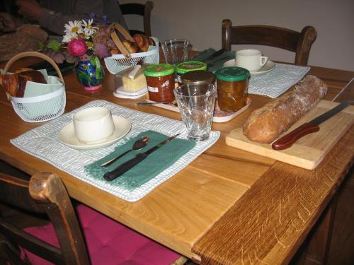 una mesa de madera con una mesa con pan. en Les Granges De Cassard en Anglars