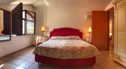 a bedroom with a red bed and two lamps at Casa Santicelli Maratea ' I CARPINI ' in Maratea