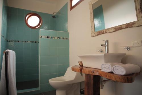 y baño con lavabo, aseo y ducha. en Casa Dibulla Hotel Boutique, en Dibulla
