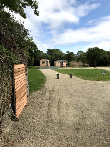a dirt road with a wooden fence in a field at Beds of Silk in Labasheeda